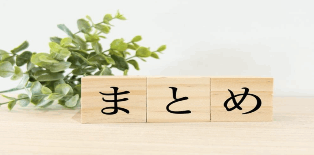 「まとめ」と書かれた木のブロックと緑の葉