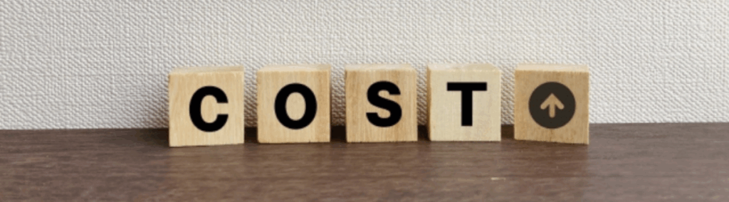 COSTの文字が書かれた木製ブロックとコスト上昇を示す矢印マーク